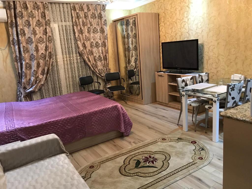 a room with a bed and a table and a television at Orbi Towers Batumi in Batumi