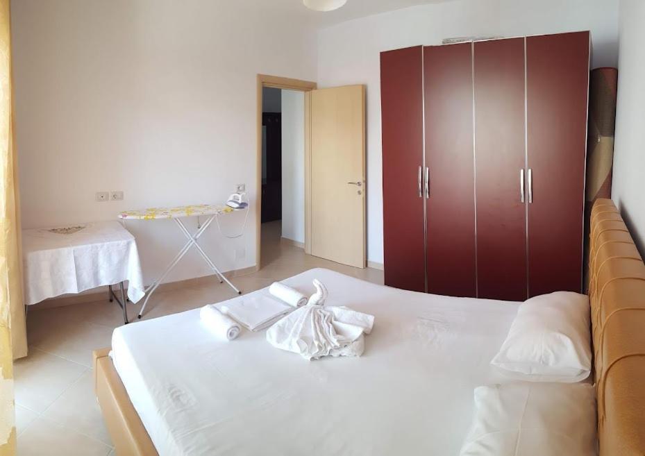 una camera con letto bianco e armadio rosso di Sarrande, big one bedroom apartment at the center a Sarandë