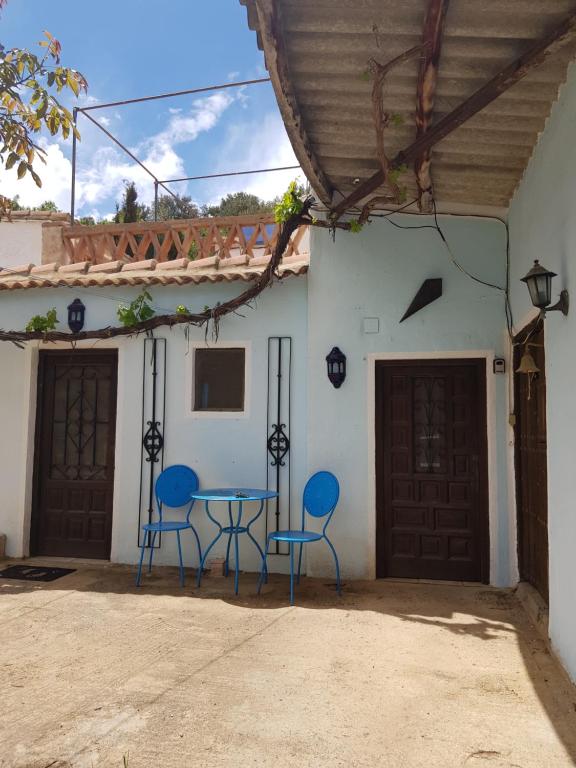 due sedie blu e un tavolo di fronte a una casa di Granja de Matias a Cádiar