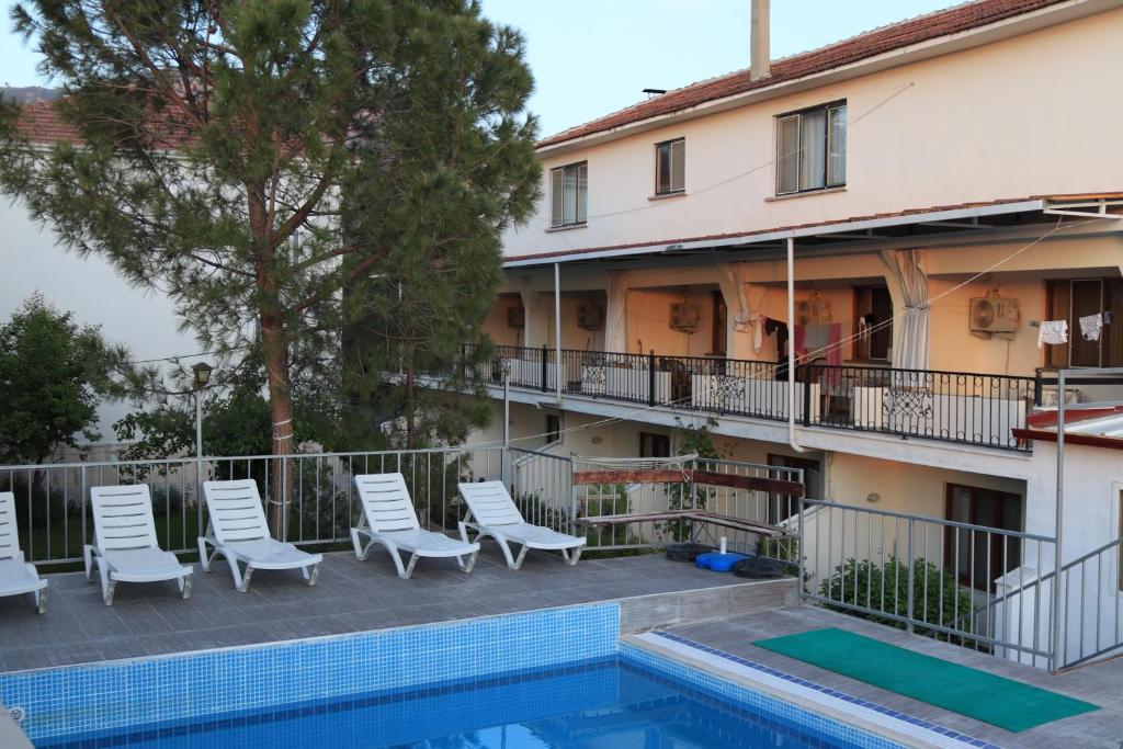 a hotel with a swimming pool and chairs next to a building at GÜNEŞ APART OTEL in Pamukkale