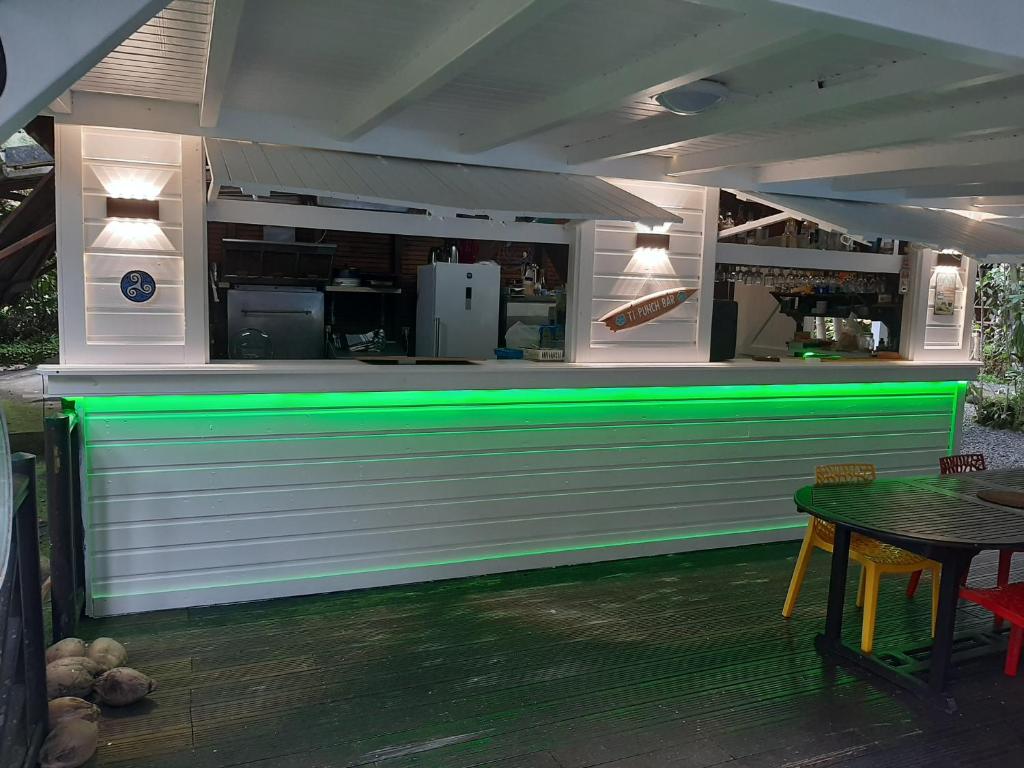 a bar with green lighting in a restaurant at Les Gîtes de la Lézarde in Petit-Bourg