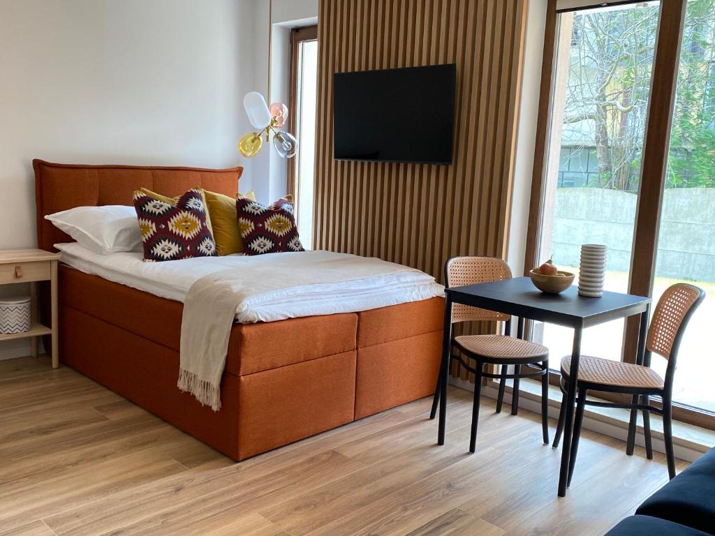 1 dormitorio con 1 cama y 1 mesa con sillas en Apartament Carmel Stegna Park, en Stegna