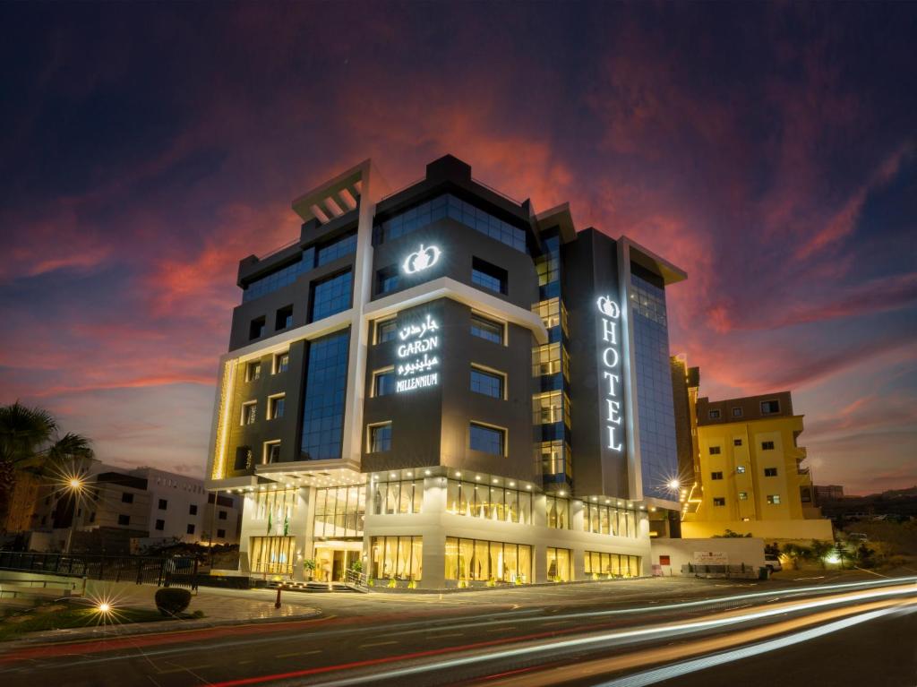 a hotel building with lights on it at night at Abha Gardn Millennium Hotel in Abha