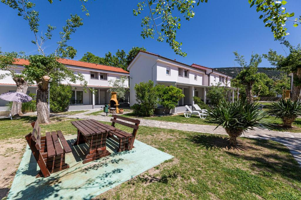 a picnic table and chairs in the yard of a house at Villas Corinthia in Baška