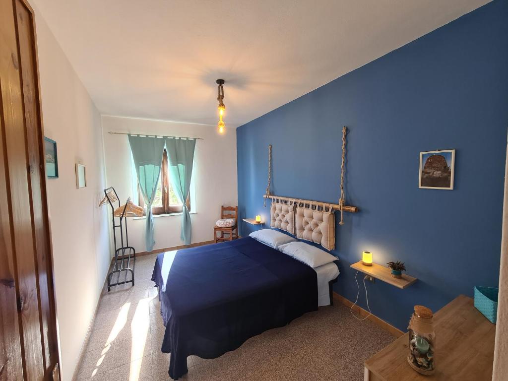 1 dormitorio azul con 1 cama con pared azul en A ca' di Pe e Giò, en Calasetta