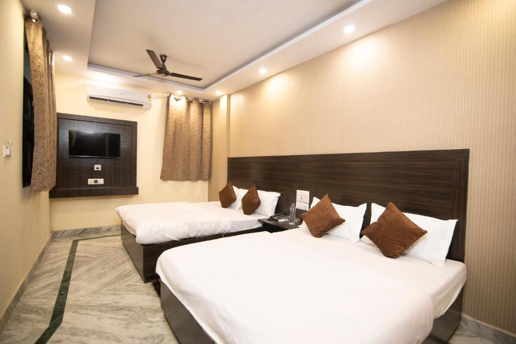 a hotel room with two beds and a television at Hotel Siddharth A Boutique Guest House in New Delhi