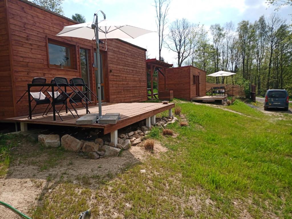 a deck with chairs and an umbrella on a house at Fox House Tisá / Rájec in Tisá