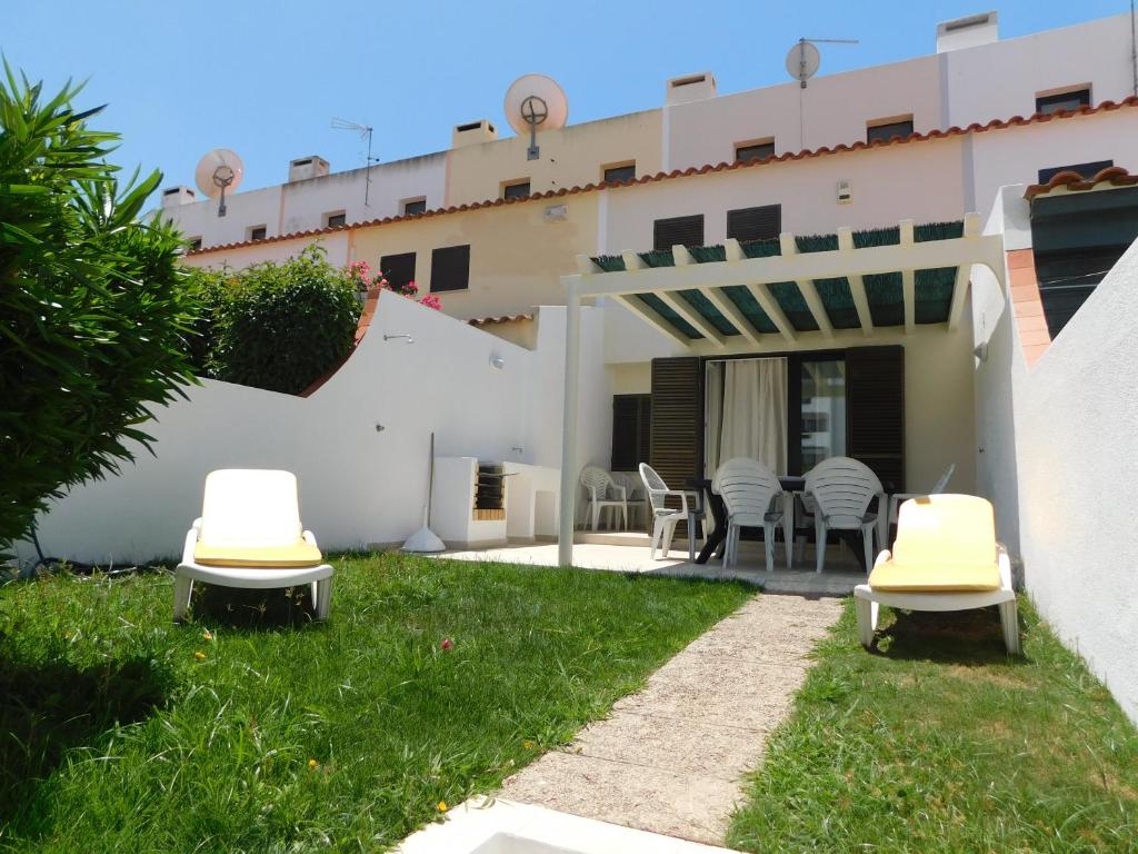 une cour avec deux chaises et un bâtiment dans l'établissement Estrela Mar Marina Villa, à Quarteira