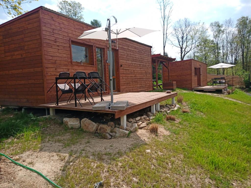 a cabin with two chairs on a wooden deck at Fox House Tisá / Rájec in Tisá