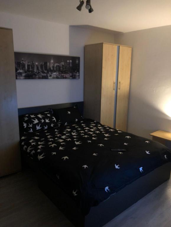 - une chambre avec un lit et une couette noire dans l'établissement Apartament situat aproape de mare, à Constanţa