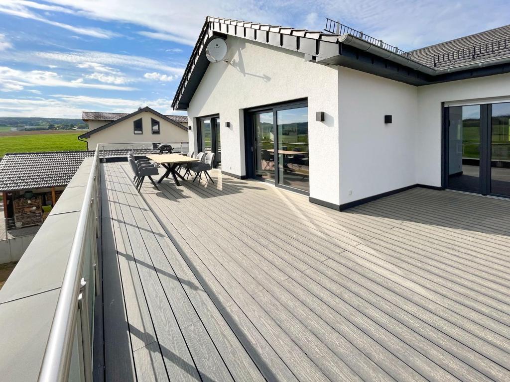 a deck with a table and chairs on a house at The View Suite in Brücktal
