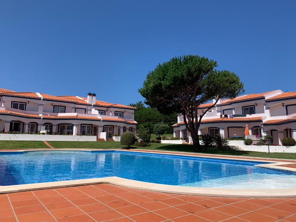 a swimming pool in front of a building at Casa da Praia - Golf Resort Praia D'El Rey in Amoreira