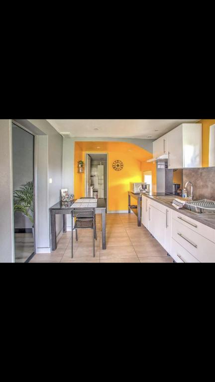 une cuisine avec une table et une salle à manger dans l'établissement Agréable Maison au calme, à Périgueux