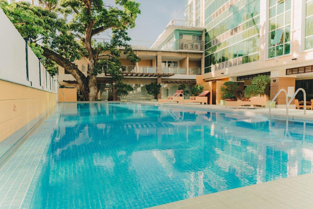 a swimming pool with a tree in the middle of a building at Ayala Mall 10mins walk Cebu City Apartment & Pool in Cebu City