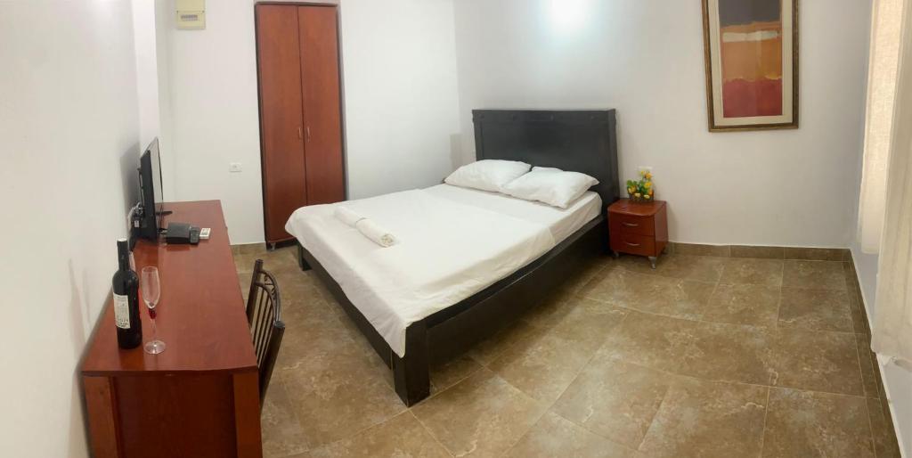 a bedroom with a bed with white sheets and two pillows at Loren Village in Neve Zohar