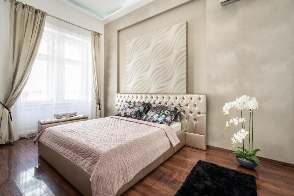 a bedroom with a bed and a large window at Opera Luxury Apartment in Budapest