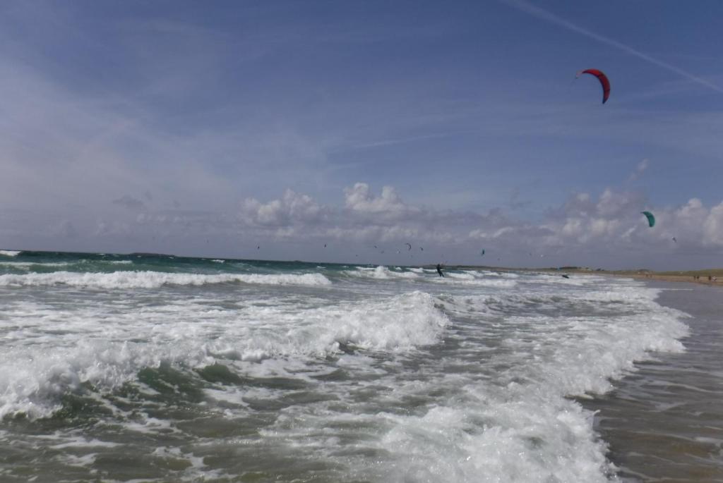 a group of people kite surfing in the ocean at Le studio du dolmen à Plouharnel in Plouharnel