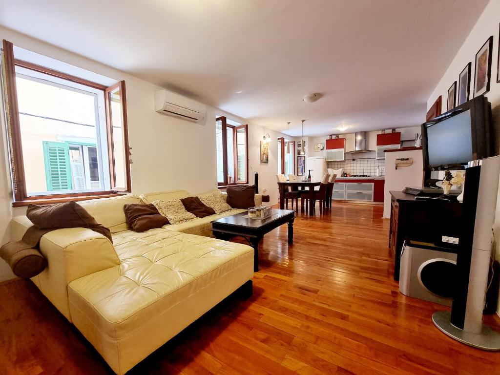 a living room with a couch and a tv in it at Apartments Lara 2 with more affordable parking in Piran