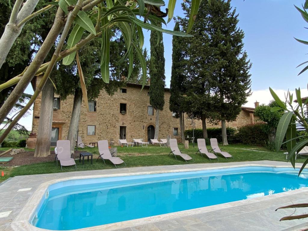 a villa with a swimming pool and a building at Il Castagnolo B&B in San Gimignano