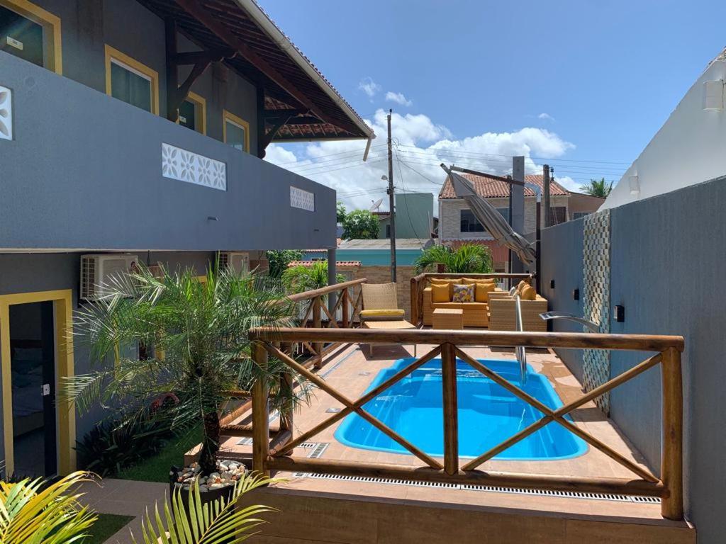 a patio with a deck and a swimming pool at Suíts Praia Bonita em Milagres in São Miguel dos Milagres