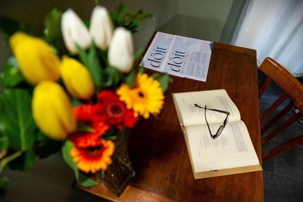 een tafel met een boeket bloemen en een boek bij döit - Turismo e Cultura in Conialo