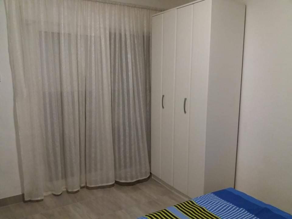 a bedroom with white cabinets and a bed and curtains at Apartment’s Maric - Zelenika,Herceg Novi in Zelenika