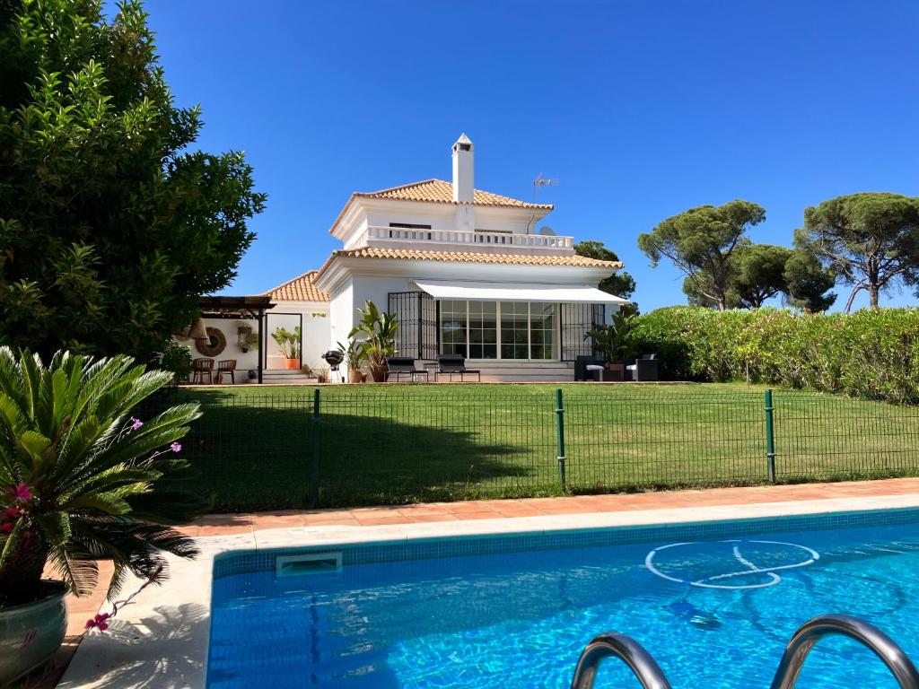 uma casa com piscina em frente a uma casa em VILLA DE LA LUZ Luxury Guesthouse em El Portil