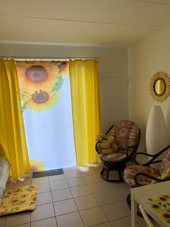 a living room with a window with yellow curtains at Carpe Diem in Jumet
