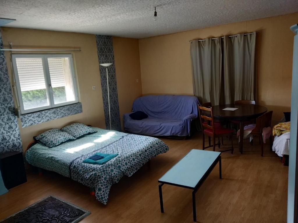 a bedroom with a bed and a table and a dining room at ferme du sapin in Daillancourt