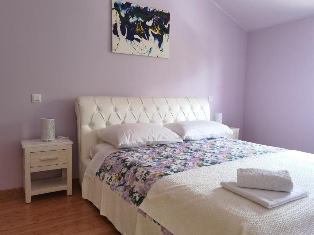 1 dormitorio con 1 cama con colcha blanca y mesa en Apartment Luce, en Pićan