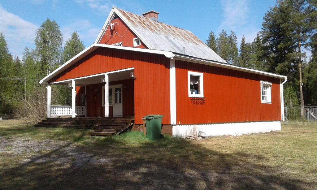 une maison orange et blanche avec une poubelle verte dans l'établissement Villa Polarktis, à Överkalix