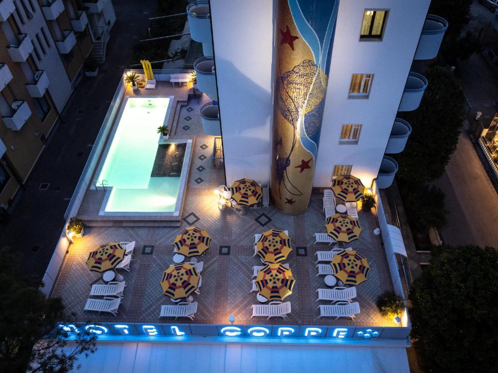 uma vista superior de uma piscina do hotel com uma prancha de surf em Hotel Coppe Jesolo em Lido di Jesolo