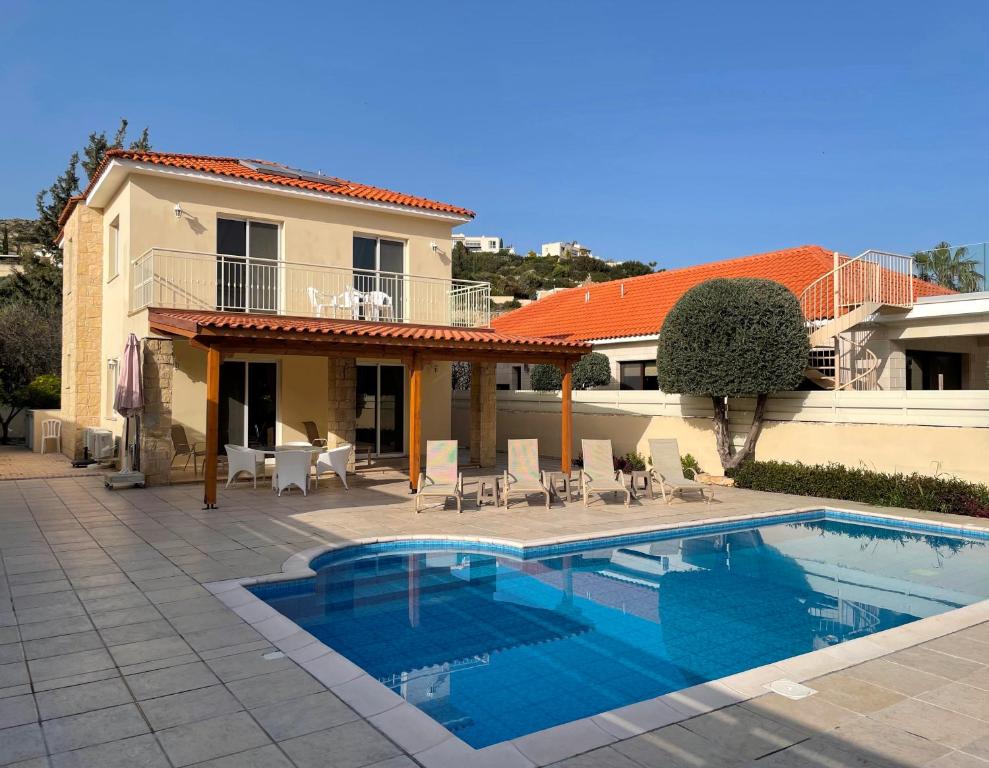 a swimming pool in front of a house at Villa Rossa in Pissouri