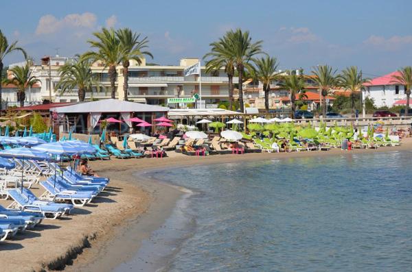 ein Strand mit Stühlen und Sonnenschirmen sowie ein Resort in der Unterkunft Studio Golfe Juan, plages, parking, climatisation in Vallauris