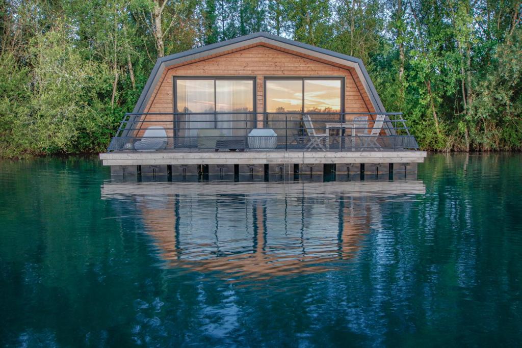 een huis op een dok op een waterlichaam bij Maison flottante - Houseboat - Baurech Insolite in Baurech