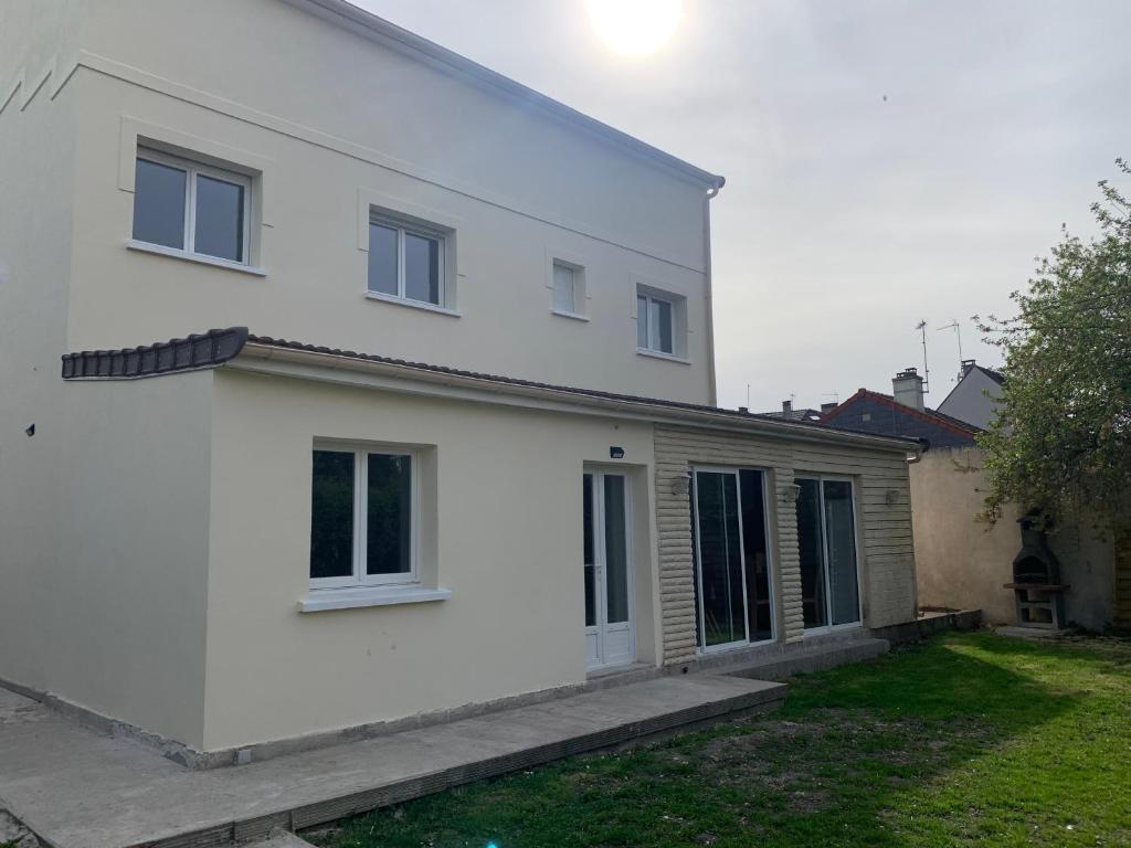 une maison blanche avec une cour devant elle dans l'établissement Villa Tenjin chambre 16, à Bondy