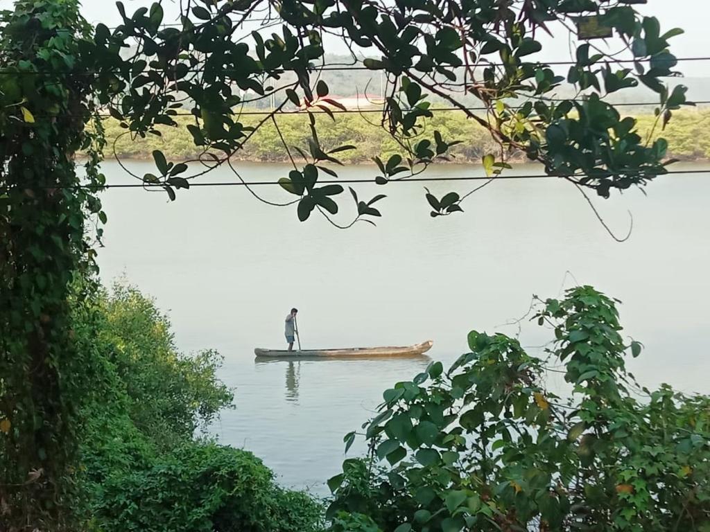 człowiek stojący na łodzi w wodzie w obiekcie Casa de Julio w mieście Porvorim