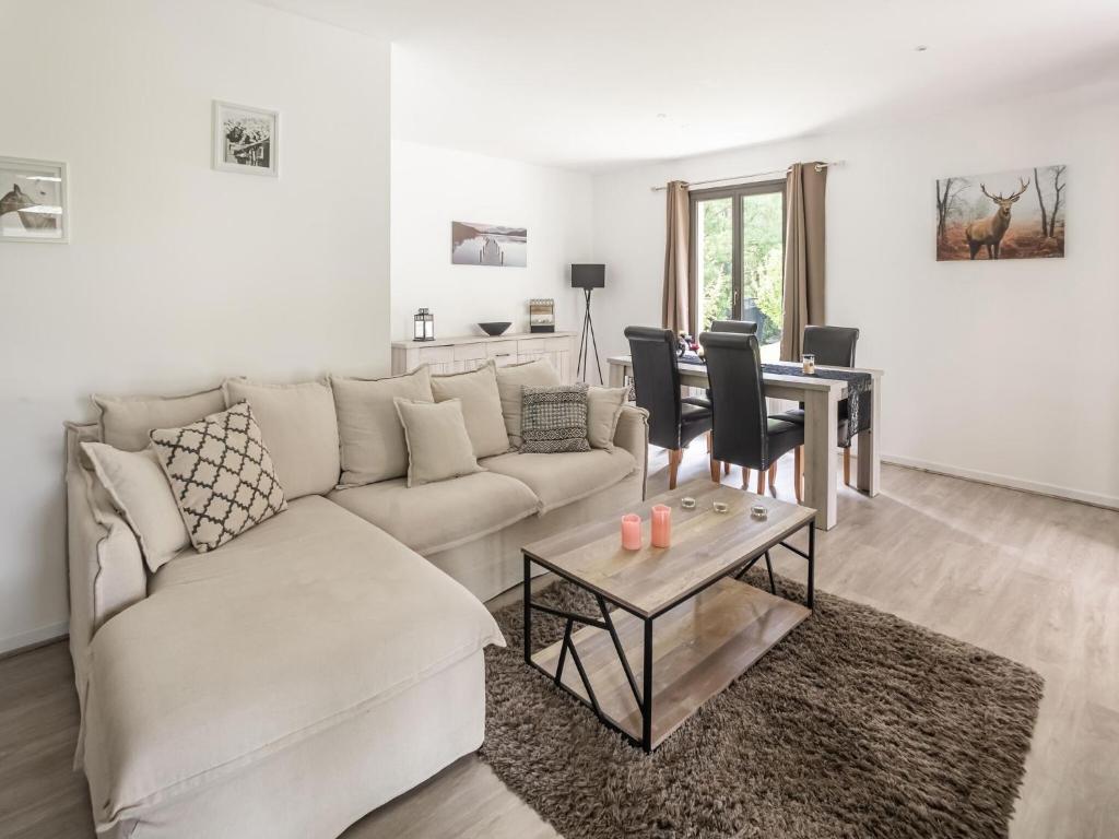 a living room with a white couch and a table at Holiday Home with Roofed Swimming Pool in Villeneuve-sur-Lot