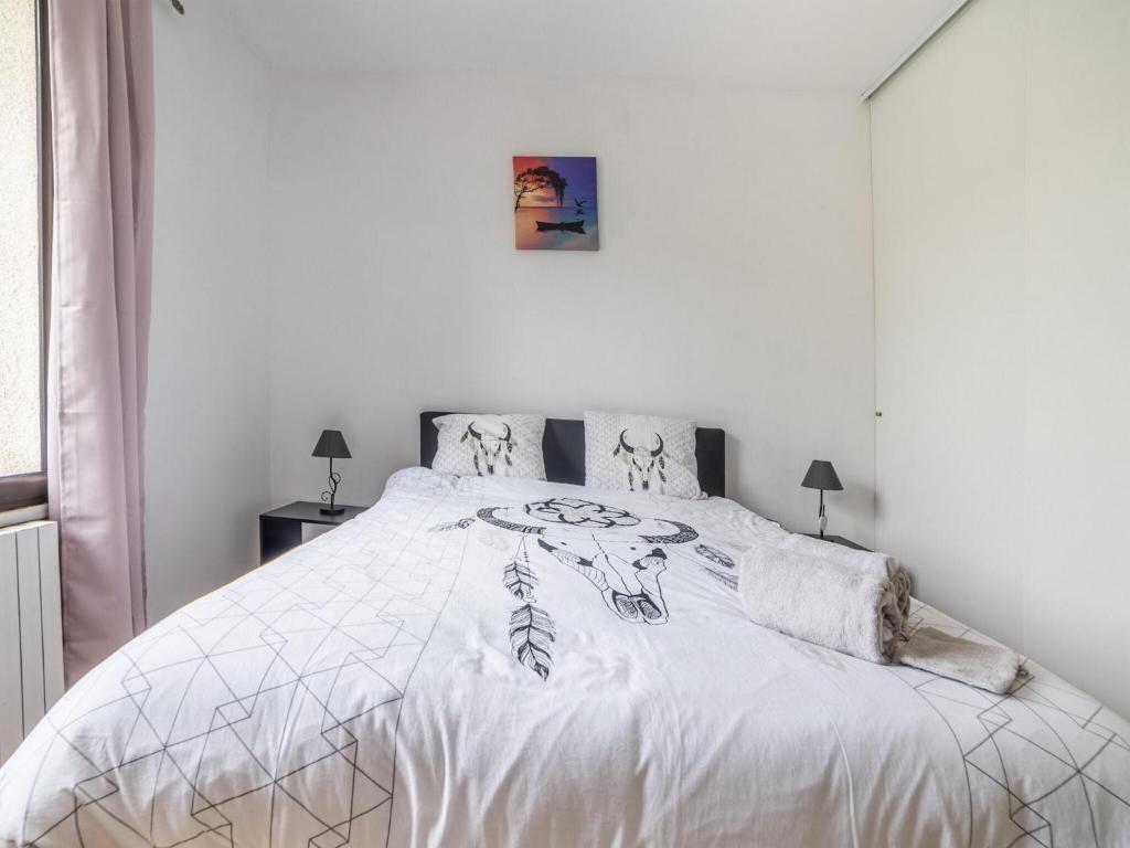 a white bedroom with a large bed with white sheets at Holiday Home with Roofed Swimming Pool in Villeneuve-sur-Lot