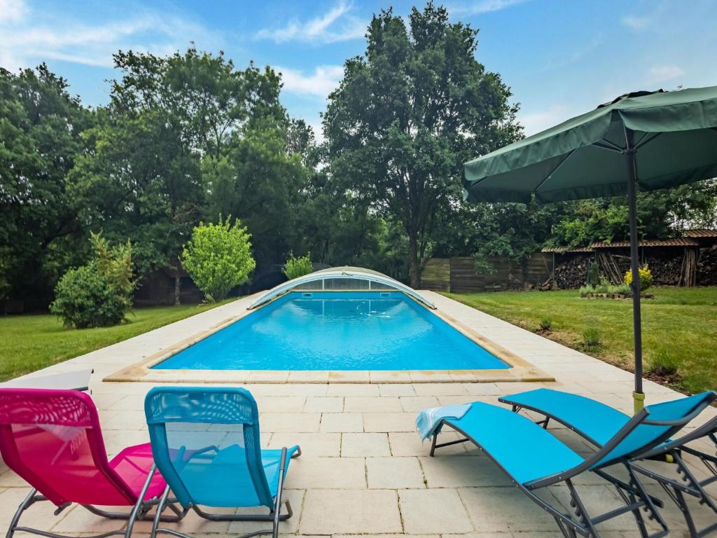 a swimming pool with chairs and an umbrella at Holiday Home with Roofed Swimming Pool in Villeneuve-sur-Lot