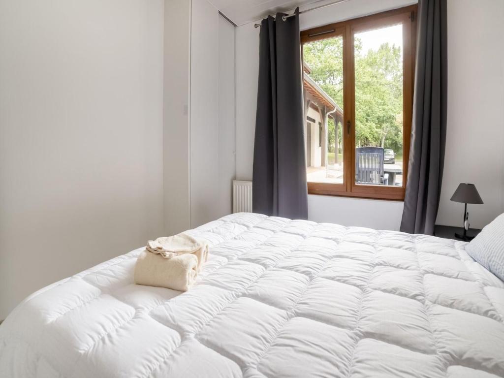 a white bed in a room with a window at Holiday Home with Roofed Swimming Pool in Villeneuve-sur-Lot
