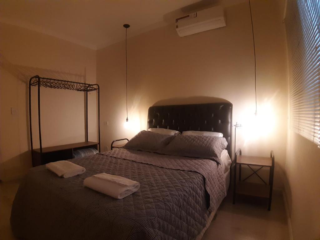 ein Schlafzimmer mit einem Bett mit zwei Handtüchern darauf in der Unterkunft Casa incrível com 2 quartos e estacionamento incluso in Maringá