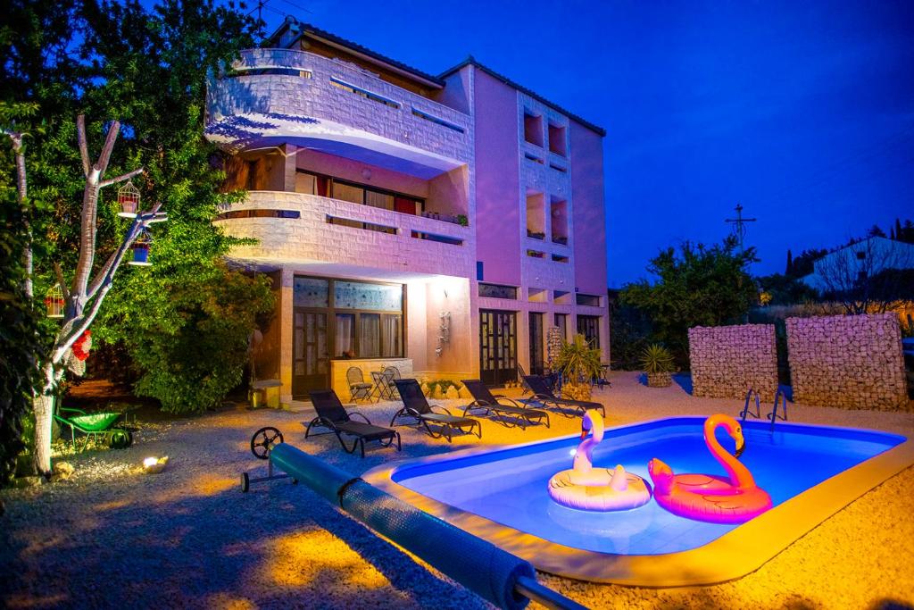 - une piscine avec deux flamants roses en face d'un bâtiment dans l'établissement Apartments Silver Tree, à Split