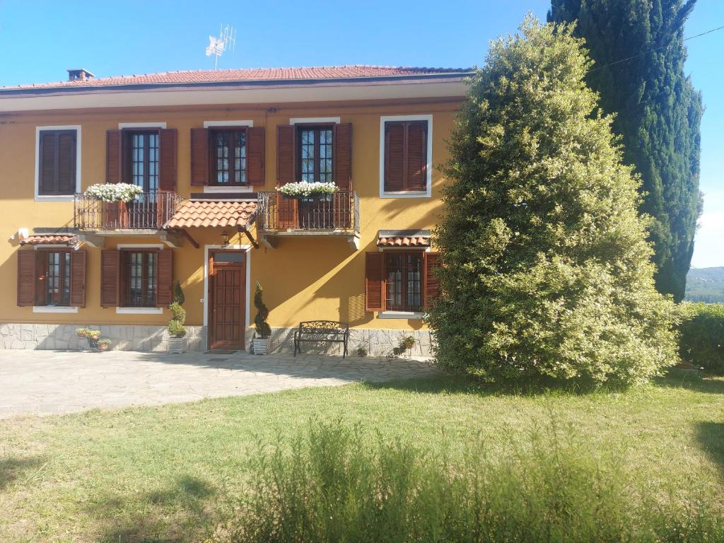 ein gelbes Haus mit einem Baum davor in der Unterkunft Casa dell'Agrifoglio in Caselette