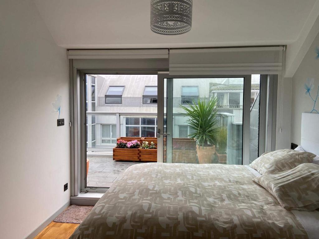 um quarto com uma cama e uma grande janela em Penthouse with terrace and views near Oza's beach em La Coruña