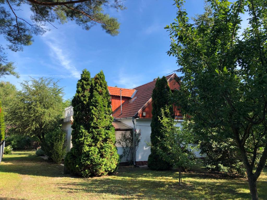 una casa con árboles delante de ella en Hortenzia Apartman, en Balatonföldvár