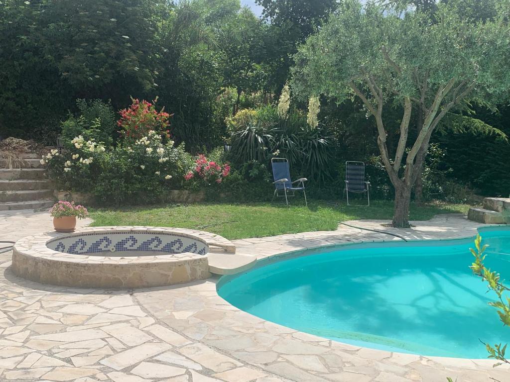 a swimming pool in a yard with a table and chairs at Studio L Oustaou in Marseille