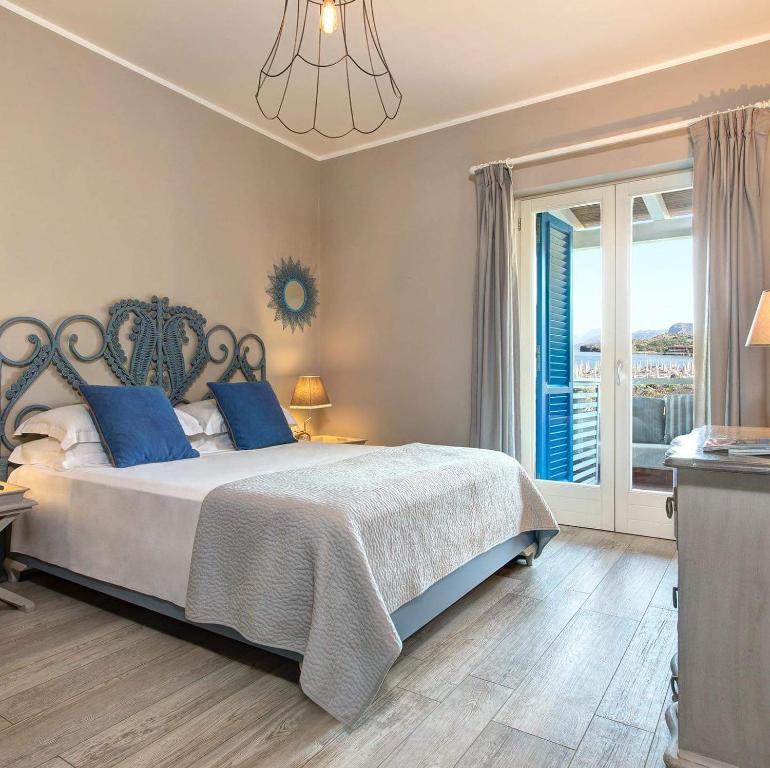 a bedroom with a large bed with blue pillows at Les Sables Noirs & Spa Multiproprietà in Vulcano