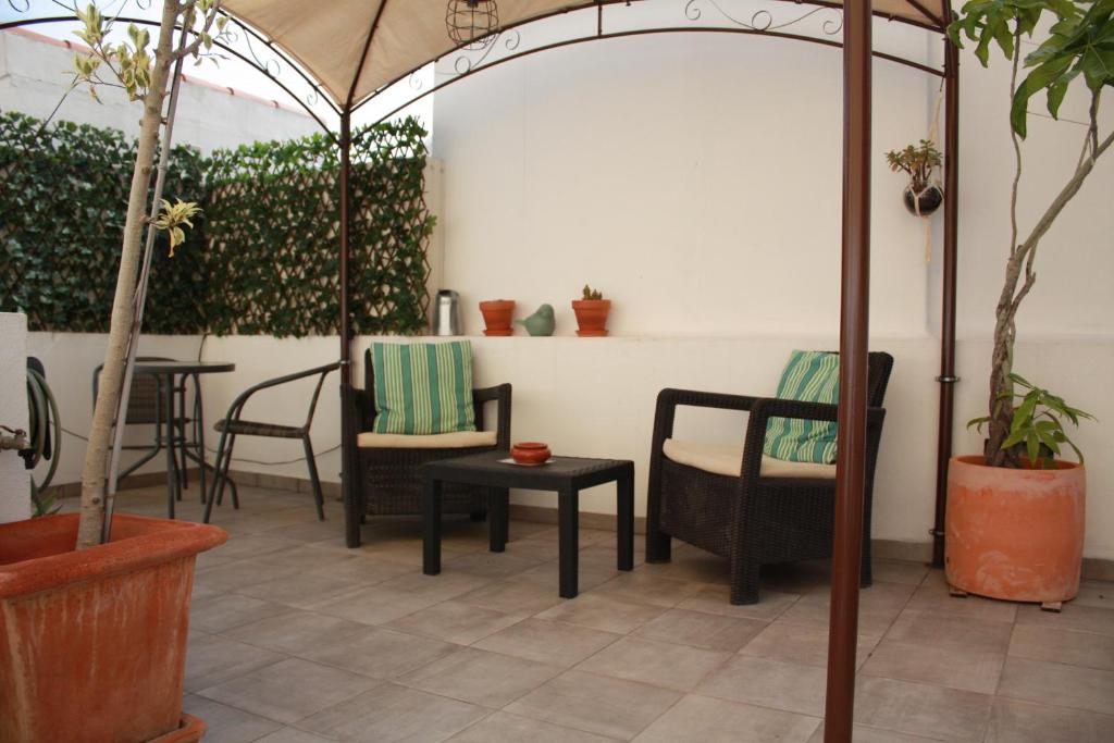 a patio with chairs and a table and plants at The Sunny Cottage in Faro