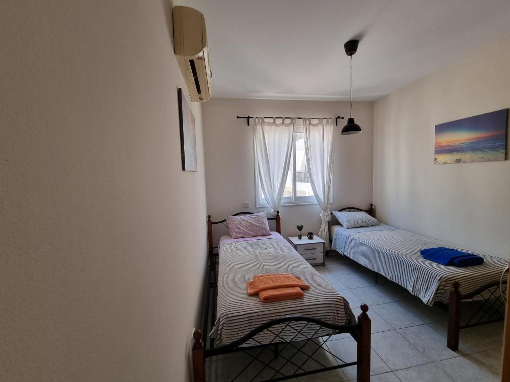 a bedroom with two beds and a window at Ancient Paphos - cozy place next to the sea, marina, historical sites, buses, mall, and market in Paphos